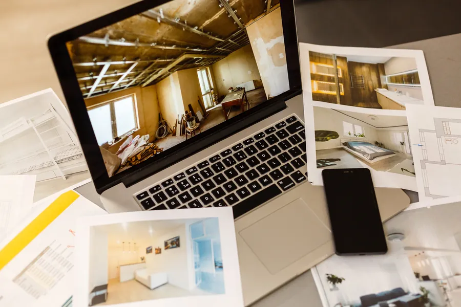 Ordinateur portable avec les propositions de projet et des planches sur la table